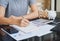 Close up of woman`s hands writing on a paper on table and working calculating monthly home expenses, taxes, bank account balance