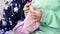 Close-up woman's hands with yarn are knitting handmade wool clothes against the background of the Christmas tree in