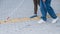 Close-up of a woman's legs accompanying a blind elderly lady outdoors.