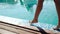 Close up on a woman\'s legs as she walks next to a pool, 20s. 1080p Slow Motion