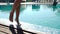 Close up on a woman\'s legs as she walks next to a pool, 20s. 1080p Slow Motion