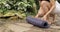 Close-up of woman\'s legs caming to the beautiful botanical garden for doing yoga exercises. She lays out a rug on a