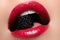 Close-up of woman\'s lips with bright fashion red glossy makeup. Macro bloody lipgloss make-up. Red lips. Open mouth