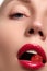 Close-up of woman\'s lips with bright fashion red glossy makeup. Macro bloody lipgloss make-up. Red lips. Open mouth