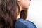 A close-up of a woman`s shoulder showing dandruff. Dark female hair. White background. The concept of dandruff and pediculosis