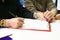 Close-up of a woman signing a health insurance contract at a meeting, sitting at a table in the office, the patient