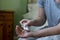 Close Up Of Woman Sitting On Bed Wearing Pyjamas Taking Medication From Packet Of Pills