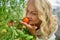 Close-up woman sniffing growing ripe tomato
