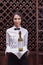 Close-up woman sommelier standing with bottle of wine and glass on tray