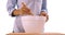 Close up of woman stirring food contents in big white bowl.