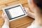 Close up of woman with tablet pc on wooden table