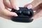 close-up of a woman taking out a black wireless earbud from his charging box. Female hands touching