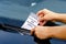 Close-up Of A Woman Taking Parking Ticket On Car`s Windshield