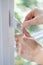 Close Up Of Woman Turning Key In Window Lock