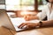 Close up of woman typing keyboard on laptop in coffee shop. People and technology concept. Freelance and Lifestyle theme.