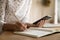 Close up of woman use cellphone write in notebook