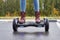 Close up of woman using hoverboard on asphalt road. Feet on electrical scooter outdoor