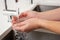 Close Up Of Woman Washing Hands At Kitchen Sink