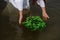 Close-up of woman in white dress in the water. Art Woman with wreath in river. Wet witch Girl in the lake