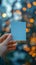 Close up Womans hand holding small blue paper with bokeh backdrop