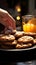 Close up Womans hand reaches for chocolate cookies, balancing them with orange juice