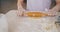 Close-up of womans hands rolling dough cooking home-made pastry at table