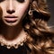 Close-up women face with long curly hair and gold jewelry