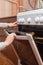 Close up of women hand opening the oven door to control the roast in the gas stove.