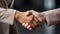 Close-up of a women Handshake between a young tanned hand with beige sleeve and a young white hand with salmon sleeve