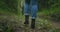 Close up of women legs hiking steep terrain in slow motion. Feet in Hiking Boots Walking on Autumn Road. woman feet