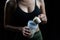 Close up of women with measuring scoop of whey protein and shaker bottle, preparing protein shake