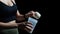 Close up of women with measuring scoop of whey protein and shaker bottle, preparing protein shake