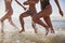 Close Up Of Women Running Through Waves On Beach Vacation