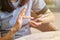 Close up of women`s hands holding cell telephone and browse mobile screen with her index finger.