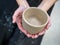 Close-up of women`s hands holding a planter made of raw clay. Handmade, workshop, workshop. Selective focus