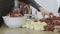 Close-up women`s hands putting beef and pork meat and onion through mincer at home. Front wiev.