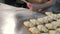 Close-up of women's hands twisting bagels with raspberry filling from the dough. Women's hands twist pieces of