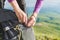 Close-up of women`s hands unfasten the buckle on the camp backpack against the background of the valley in the setting