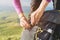 Close-up of women`s hands unfasten the buckle on the camp backpack against the background of the valley in the setting