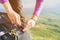 Close-up of women`s hands unfasten the buckle on the camp backpack against the background of the valley in the setting