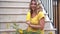 Close up of women in yellow t-shirt, closing yellow reusable steel bottle