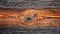 A close up of a wood plank with a hole in it