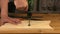 Close up of Wood Worker using an electric hand drill to drill a hole through the plank