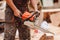 Close-up of woodcutter lumberjack is man chainsaw tree