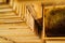 Close-up of wooden bee frames hanging on a shelf in honeybee house.