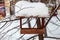 Close-up of a wooden birdhouse bird feeder covered with a large layer of snow on a clear winter day in a forest suspended from a