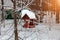 Close-up of a wooden birdhouse bird feeder covered with a large layer of snow on a clear winter day in a forest suspended from a