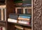 Close up of wooden book case with lots of books. Blurred background.