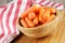 Close up of wooden bowl filled with delicious Baby Carrots