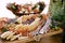 Close-up of a wooden cutting board with meat and cheese cuts and a grape cube on the background of a salad bowl with